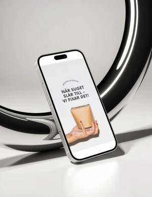 Annons på mobilskärm med hand som håller en brun pappersförpackning och texten 'När suget slår till - vi fixar det!