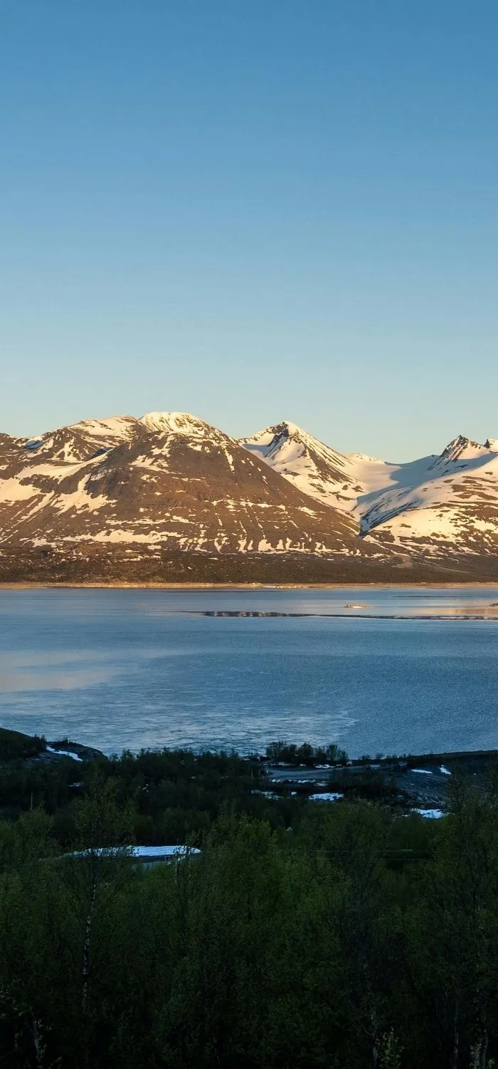 Utsikt över snöklädda fjäll och sjö i Gällivare.